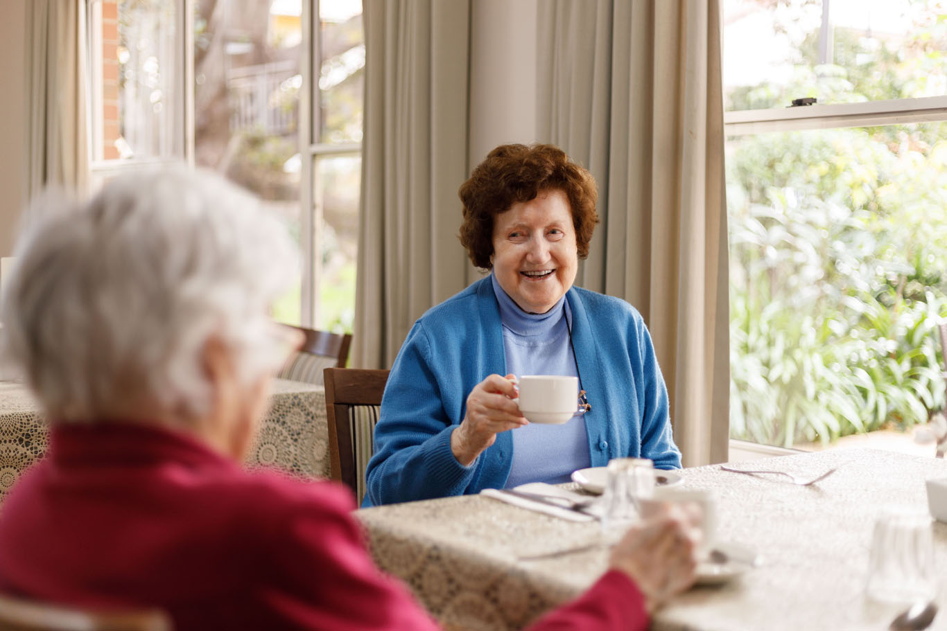 an aged care resident having a cup of tea in the dining room